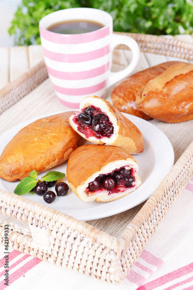 Fresh baked pasties with currant on plate on table close-up