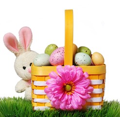 Wall Mural - Easter basket with colorful eggs and rabbit on green grass