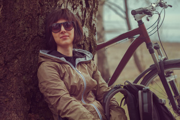 Poster - Traveler cyclist rests near a tree