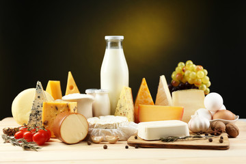 Wall Mural - Tasty dairy products on wooden table, on dark background
