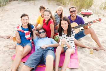 Wall Mural - group of friends with guitar having fun on beach