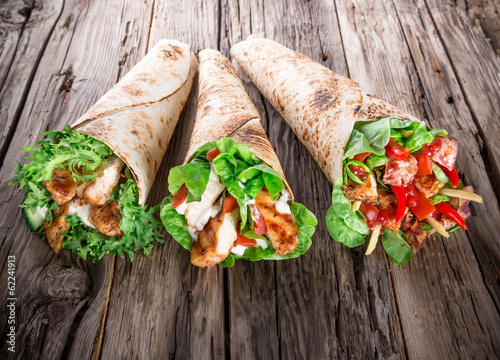 Fotografía Chicken slices in a Tortilla Wrap on wood.
