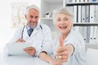 © WavebreakMediaMicro - Happy senior patient gesturing thumbs up with doctor