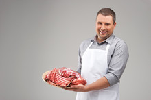 Professional Butcher Smiling And Holding Raw Meat.
