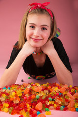 Wall Mural - Young girl in a pool of colorful candy