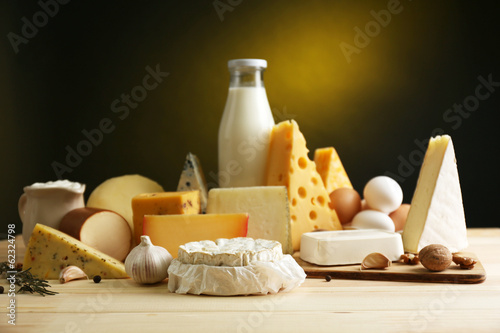 Fotografía Tasty dairy products on wooden table, on dark background