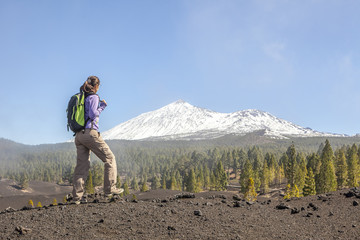 young woman on top of a mountain enjoying the view of volcano te