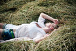 © stormy - Young beautiful woman lying on hay one summer day