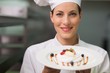 © Wavebreak Media - Happy chef smiling at camera holding dessert plate