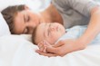 © Wavebreak Media - Mother sleeping with baby son on bed