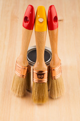 Poster - Can of paint with paintbrushes on wooden table