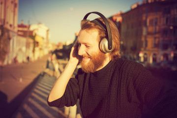 Wall Mural - young stylish bearded man listening to music