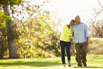 senior couple walking through autumn woodland