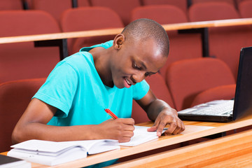 Wall Mural - male african college student writting classwork