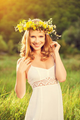 Wall Mural - beautiful woman in wreath of flowers lies in the green grass out