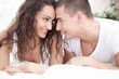 © V&P Photo Studio - smiling young couple in love lying in bed