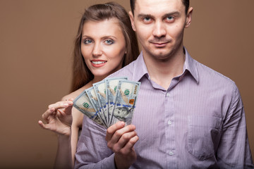 Fashion beautiful couple in love holding money the family budget