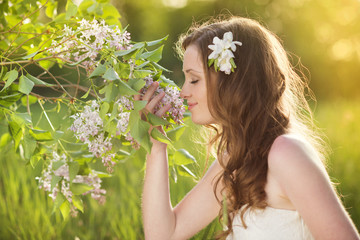 Beautiful spring girl with flowers on the meadow