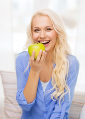 smiling woman with green apple at home