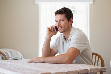 Wall Mural - Side view of a young man using mobile phone