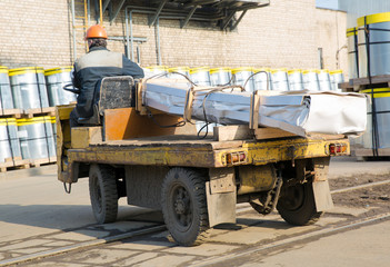 Factory Laborer Driver Transporting Cargo on Electric Vehicle