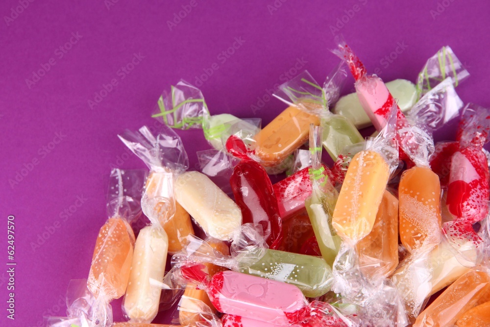 Tasty candies on purple background