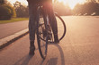 © LoloStock - Young woman cycling in the park at sunset
