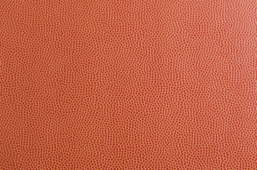 Close-up texture of a basketball ball. Textured surface designed for grip. The pattern is uniform and repetitive, highlighting the iconic design of sports equipment.