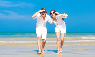 Wall Mural - Front view of young couple in white  at the sea