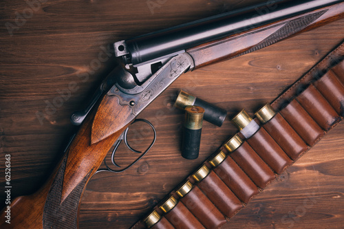 Fotomural Shotgun with shells on wooden background