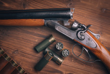 Shotgun With Shells On Wooden Background