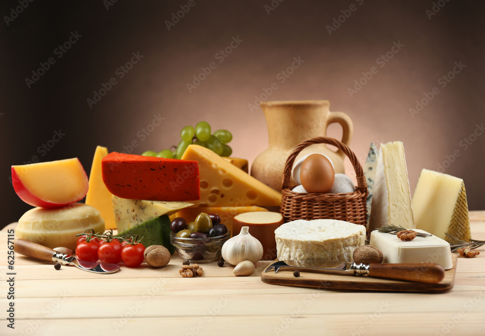 Tasty dairy products on wooden table, on dark background