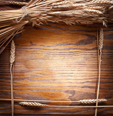 Canvas Print - Ears of wheat on old wooden table.