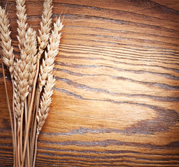 Canvas Print - Ears of wheat on old wooden table.