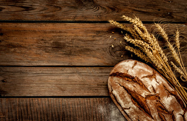 Rustic bread and wheat on vintage wood table