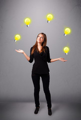 young lady standing and juggling with light bulbs