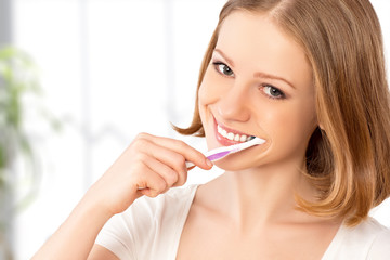 Wall Mural - happy woman brushing her teeth with a toothbrush