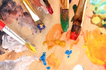 Canvas Print - Many brushes in paints on multicolor wooden background