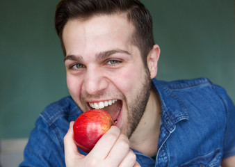 Healthy young man eating apple