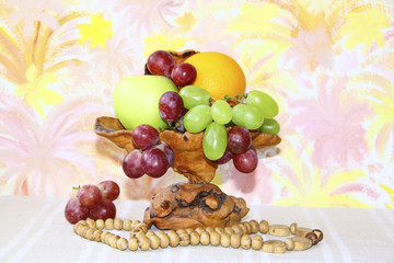 Exclusive wooden vase with apples, grapes and oranges on abstrac