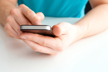 Wall Mural - male hand holding a cell phone and writing