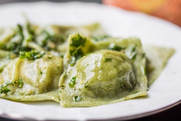 Canvas Print - Ravioli pasta from green dough with mushroom stuffing, oil