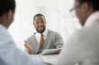 © Mint Images - Office Interior. Three People Sitting Around A Table At A Business Meeting.