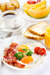 Wall Mural - Breakfast with fried eggs, coffee,  juice, croissant and fruits