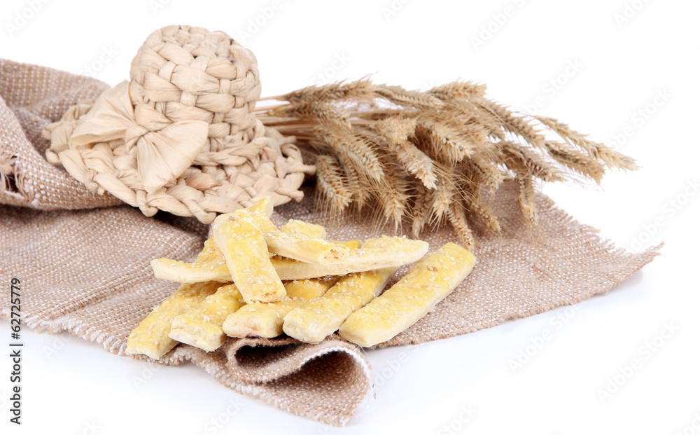 Tasty bread sticks on sackcloth isolated on white