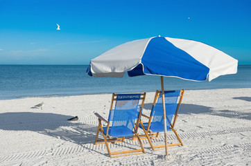 Wall Mural - sun loungers and a beach umbrella on silver sand, vacation