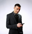 © Drobot Dean - Happy businessman using smartphone over gray background
