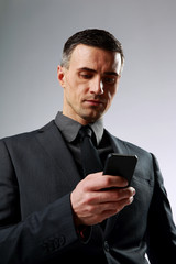 Sticker - Businessman using smartphone over gray background