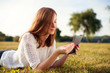 © baranq - Beautiful young woman with digital tablet in park