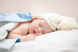 © golovianko - Cute sleeping baby in knitted hat with pompom